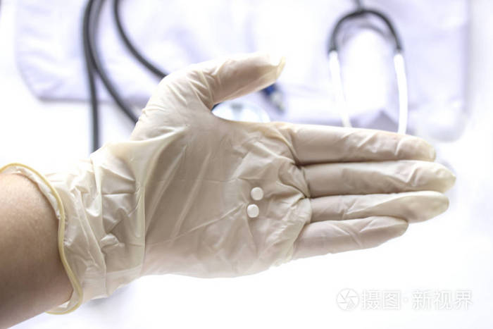 护士的手在手套持有药丸