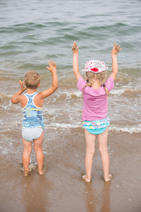 孩子们站在沙滩上, 用双手迎接它。