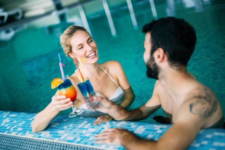 快乐迷人情侣在水疗游泳池放松身心