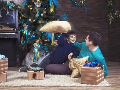 快乐男孩玩耍着他的父亲在圣诞节