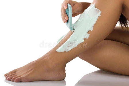 妇女用剃刀刮腿毛的特写镜头图片