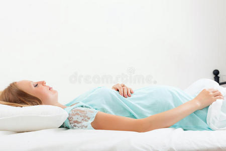 睡在白床单上的孕妇
