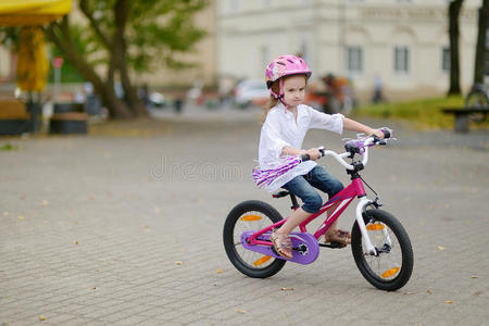在城市里骑自行车的小女孩