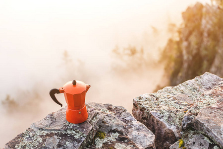 咖啡壶, 在户外的岩石悬崖上站在热的咖啡馆。徒步旅行和野营厨房用具和齿轮概念