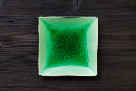 顶视图绿色方形碟暗棕色的桌子上