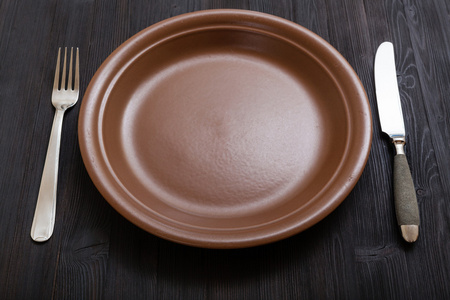棕色板用刀，把汤匙放暗棕色的桌子