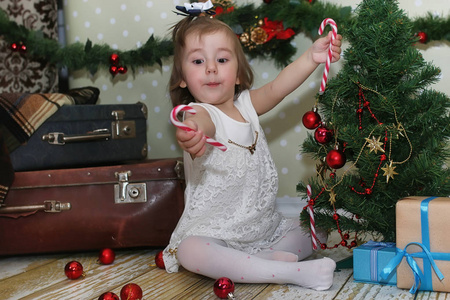 小女孩坐在一棵圣诞树