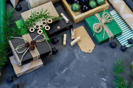 新的一年牛皮纸和圣诞礼物的包装, 绿色和黑色。装饰节日的材料。生态型风格的自然装饰