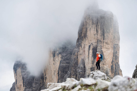 登山者在高岩石背景。体育和活跃生活概念。探险和旅行在山区域在白云岩, 意大利