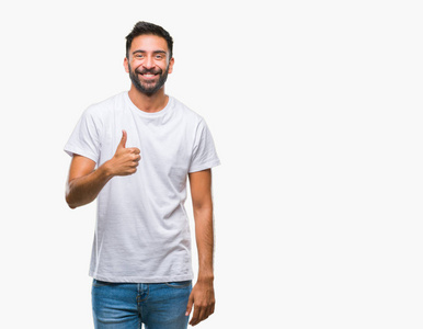 成年西班牙裔男子在孤立的背景下做快乐大拇指手势与手。批准表达式看相机与显示成功