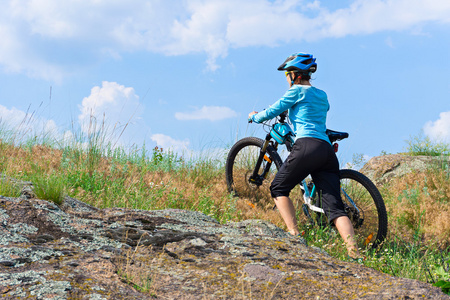 她徒步攀爬岩石的山自行车骑单车的女子图片