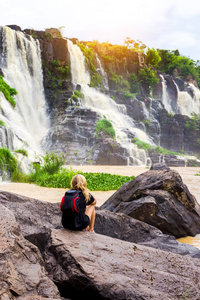 女人坐在 Pongour 瀑布美丽的瀑布