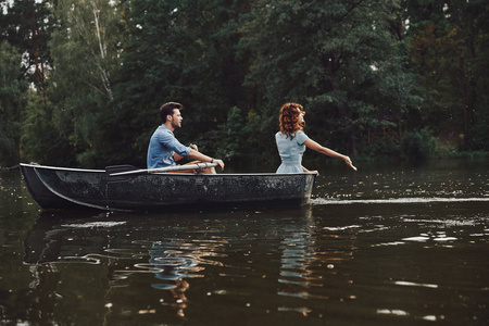 夫妇在河划船时享受浪漫约会图片