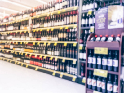 模糊的抽象葡萄酒过道与价格标签在美国德克萨斯州的杂货店。弥散在超市货架上排红白葡萄酒酒瓶。酒精饮料概念背景