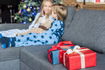 特写观看圣诞礼物和孩子们穿着睡衣坐在沙发后面