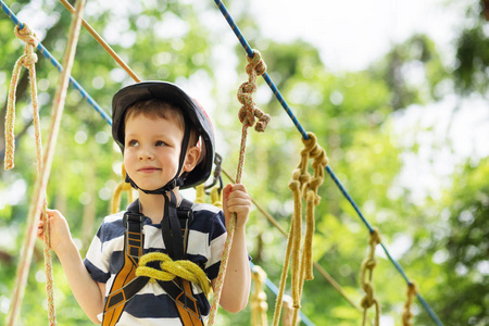 孩子们爬在冒险公园。男孩喜欢攀爬绳子