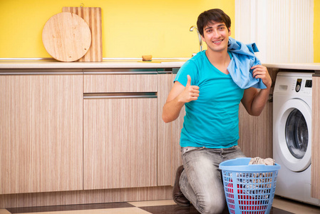 年轻的男人洗衣服在家里