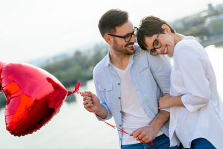年轻夫妇爱情约会和微笑室外按住心气球