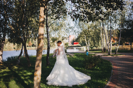 年轻的新娘穿着婚纱，抱着花束