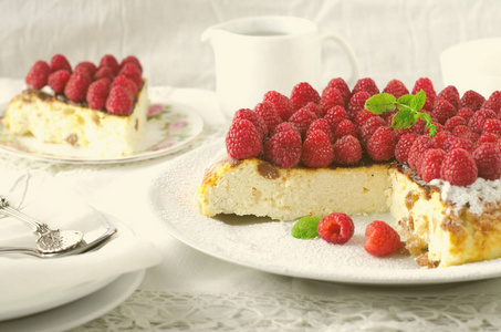 芝士蛋糕，蛋奶酥，奶油慕斯，有新鲜树莓和薄荷叶在白板上的布丁甜点