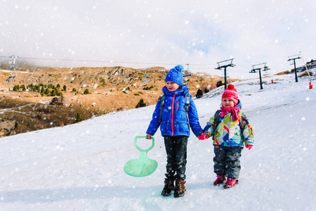 孩子们冬天好玩小男孩和女孩在雪中滑动