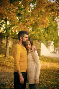 爱情关系和浪漫。在黄树叶子的男人和女人。情侣在秋季公园恋爱。秋天快乐的情侣和男孩子在户外。自然季节和秋天假日