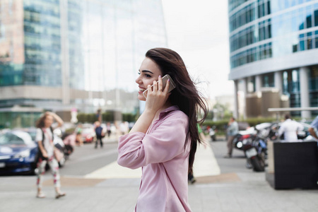 快乐成功的女商人打电话外, 微笑的女企业家通过手机远程交谈, 走在城市街道上, 漂亮的经理打电话
