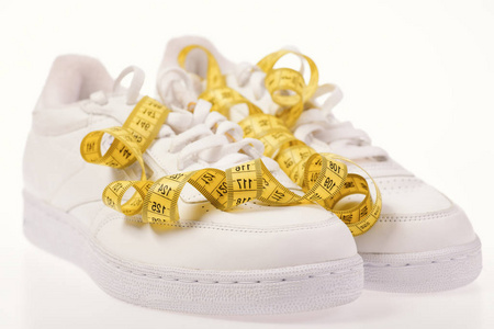 白色背景测量磁带的运动鞋图片