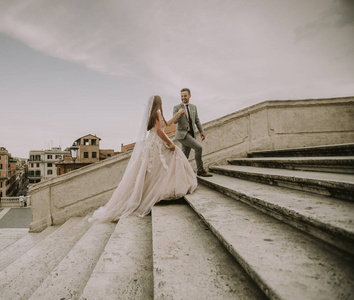 爱新娘和新郎在 Spagna 广场和 Trinita 在意大利罗马的蒙蒂散步