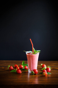 桌上的玻璃杯中的草莓鲜甜果汁