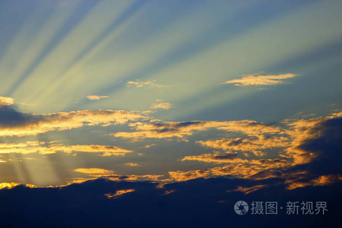 在黄蓝的天空中看到美丽的乌云.云彩和天空在下午.太阳在云层后面.