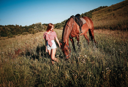 美丽的女子在田野与马