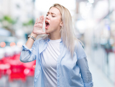 年轻的金发女郎在孤立的背景下大叫, 大声尖叫到一边与手在嘴上。沟通理念