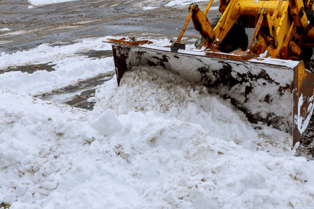 特写平地机清理雪覆盖的道路后暴雪挖掘机雪删除在一个下雪的停车场