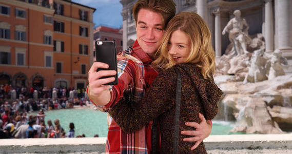 快乐的年轻夫妇在特雷维喷泉前享受乐趣自拍