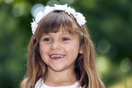 一个美丽的小女孩的肖像, 蓝色的大眼睛和花朵在她的头发。快乐, 快乐, 长大, 玩耍