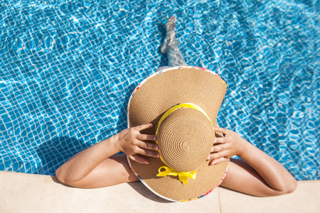 一顶帽子，享受游泳池里的女人