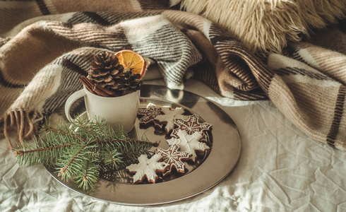杯与圆锥和干橙色与火花, 冷杉树枝, 圣诞饼干, 舒适的针织毯子, 新年, 圣诞节静止不动的生活