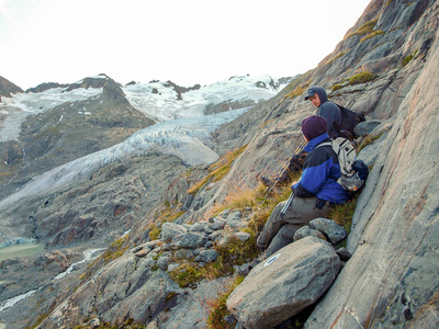 年轻的徒步旅行者徒步旅行或与冰川山脉在后台休息在阿尔卑斯山，瑞士，