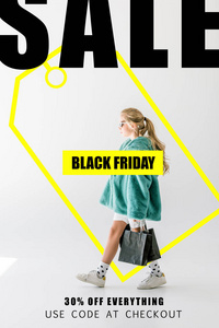 金发碧眼的女孩在绿松石皮大衣摆姿势与黑色购物袋在白色, 黑色星期五销售题词