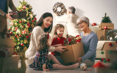 圣诞快乐, 假期愉快祖父母母亲父亲和孩子在房间里装饰这棵树。爱家庭室内