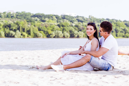 浪漫的年轻情侣坐在海滩