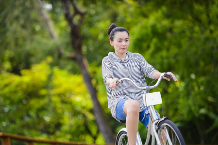 亚洲妇女骑老式自行车在公园