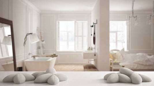 白色桌子, 桌子或搁板, 五个柔软的白色枕头, 在星星或花朵的形状, 在模糊的斯堪的纳维亚卧室与浴室, 最小的建筑室内设计概念