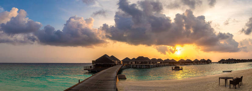 夏季傍晚在马尔代夫热带海滩上热带日落上空的全景