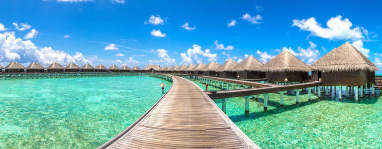 夏季马尔代夫热带海滩水上别墅 平房 和木桥全景