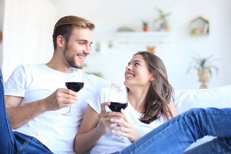 年轻情侣喝一杯红酒在客厅里