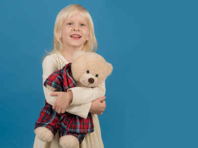 和她的玩具朋友一起玩。小孩子高兴地笑了。带着泰迪熊的小女孩。小女孩抱着玩具熊。带着软玩具的小孩。快乐的童年。我最喜欢的童年玩具