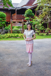 年轻女子在泰国传统服装在木房子