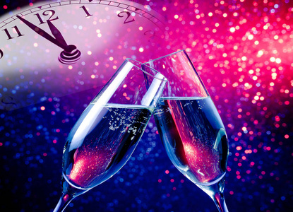 香槟酒杯与金色的泡泡，蓝色和紫色紫色光散景背景